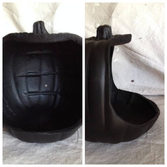 A black plastic pumpkin has been cut out of.