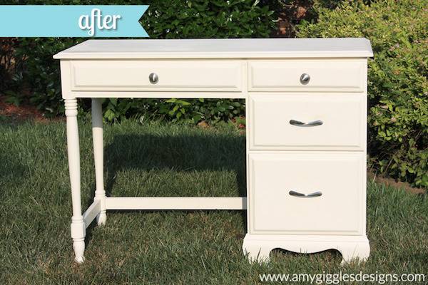 A cream colored desk sits outside in the grass.