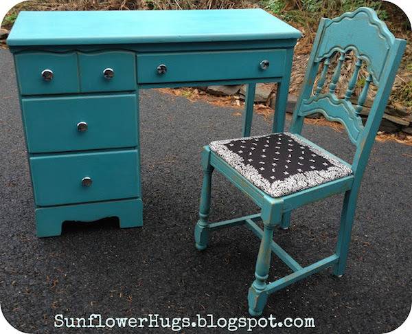 A turquoise desk & chair sit outside.