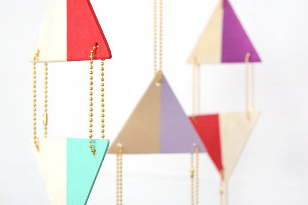 Hanging dual colored triangles attached with brass ball chain connectors.