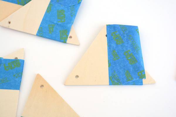 Several tan triangle boards with holes in the corners and a pice of blue tape over one side.