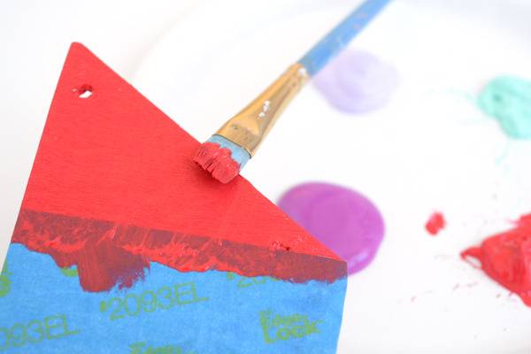 A brush is painting red and blue shapes.