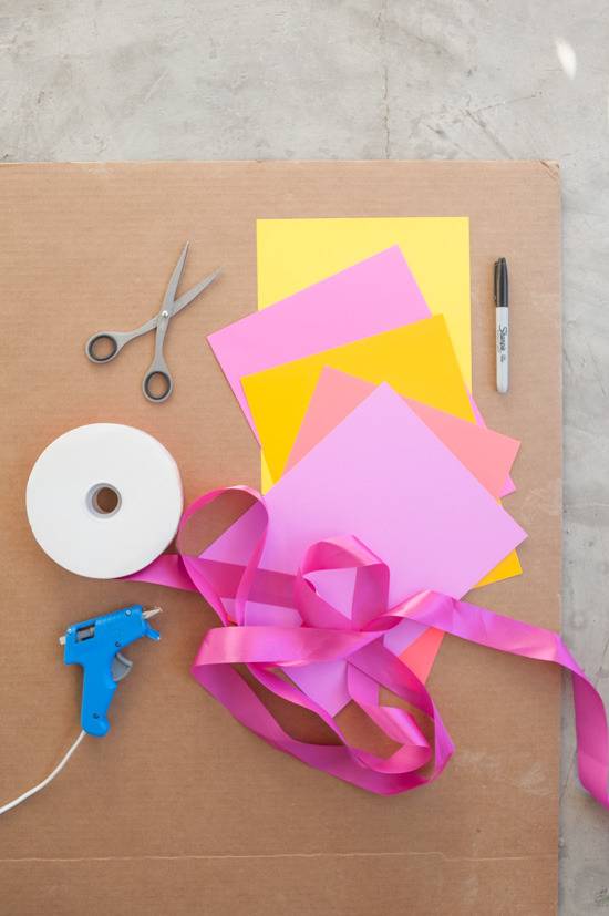 Craft tools are sitting on a cardboard sheet.