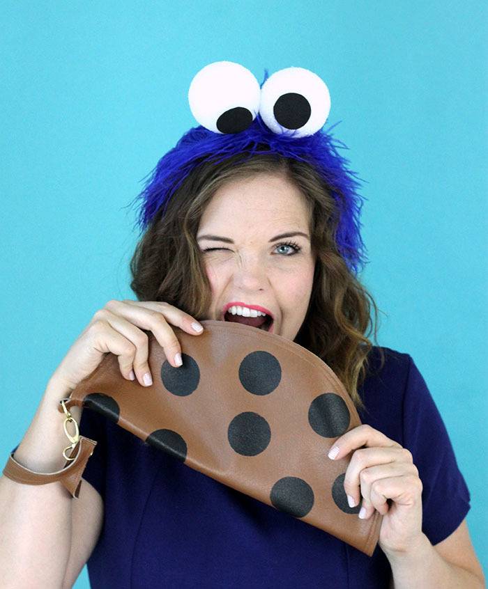 A woman in costume pretends to eat a cookie.