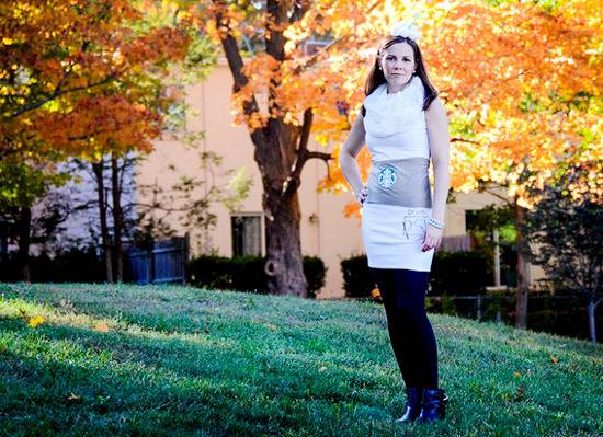 A lady dressed in white, grey and blacks standing on the grass field.