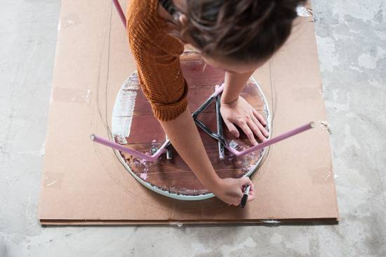 A woman cuts cardboard for a popsicle costume.