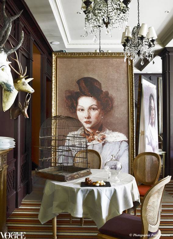 Oversized facsimiled portraits by impressionist painter Jean-Baptiste-Camille Corot, along with an old birdcage and antique wooden trophy heads