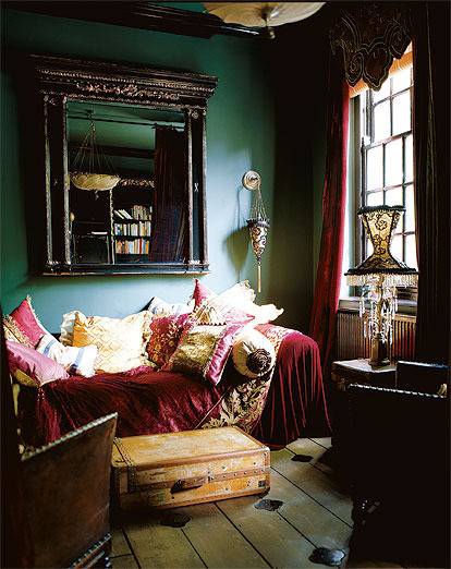 A small and messy room with cluttered pillows