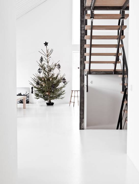 A white living space with a christmas tree and stairs