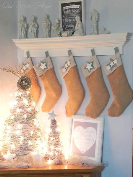 A dimly lit room has brown Christmas stockings and decorations in it.