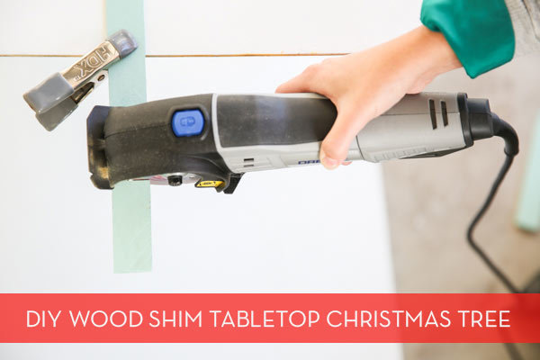 A man holding a space saving tabletop christmas tree.