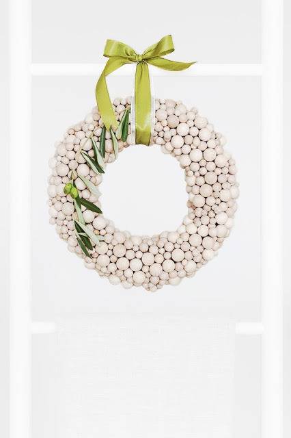 A long thin Green leaf is wrapped around and Garland made of white painted various shaped balls.