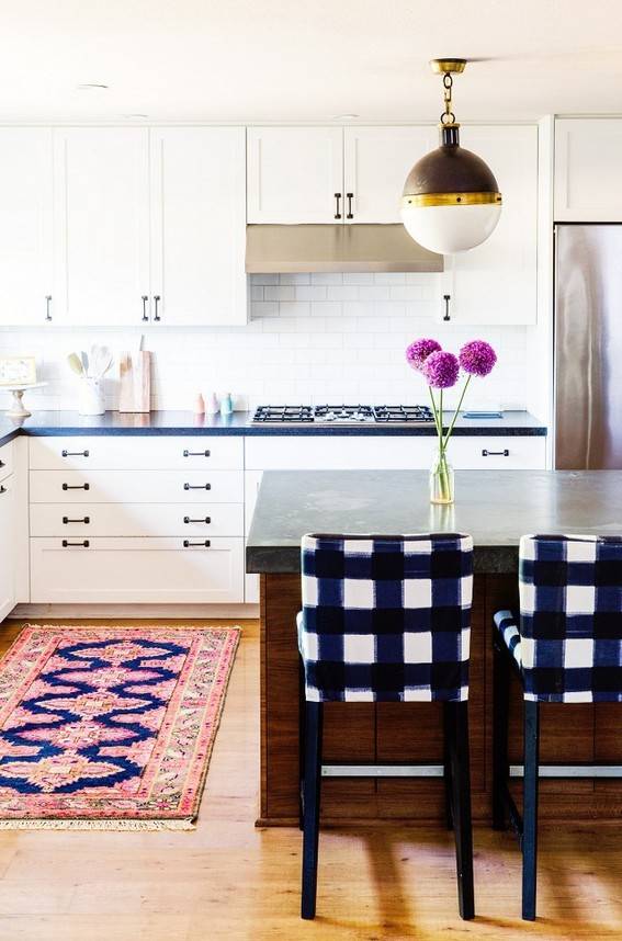 Plaid chairs sit at a counter with a purple flower on it.