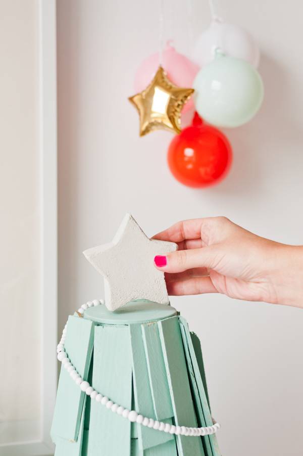 Adding a star to a homemade Christmas tree.