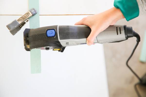 A person is using a power tool on a surface.