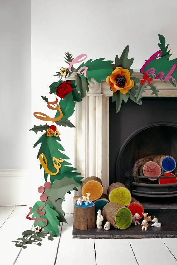 A flower wreath sits at a fireplace.