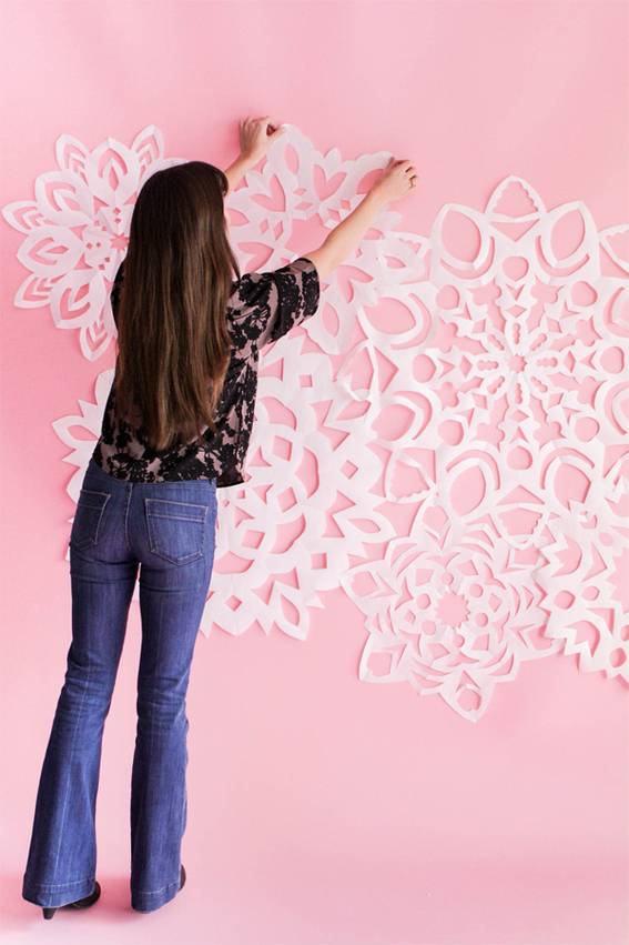 Beautiful white origami flowers decorated in a pink wall.