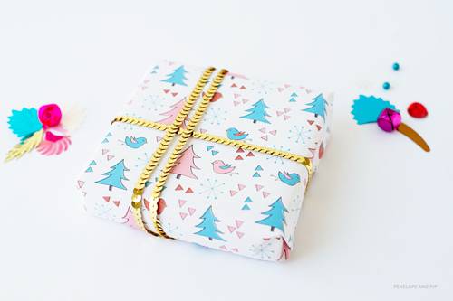 Printed white gift wrap tied with gold colored chain.