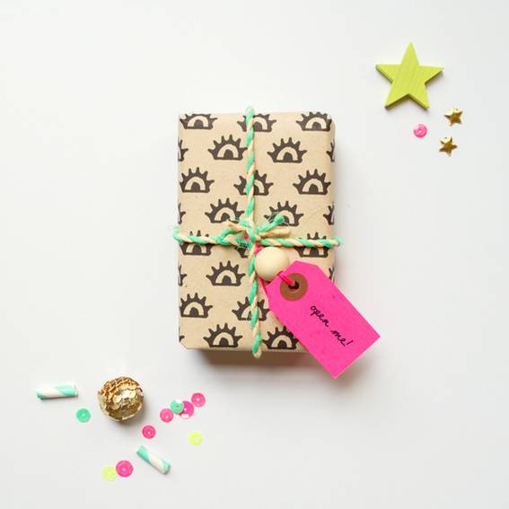 Small box gift wrapped in brown paper with green string tied around it.