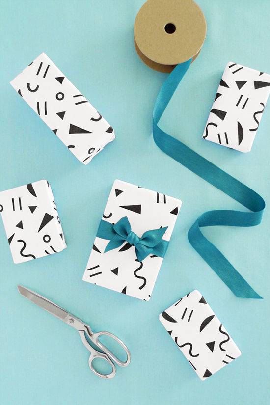Small black and white gift wrapped boxes having blue ribbon tied around them.
