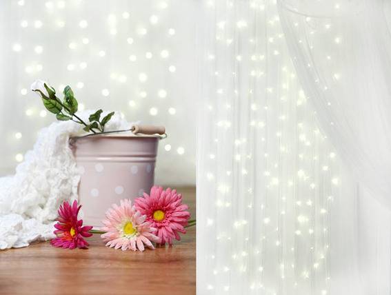 Light curtain with spotted tin with white rose and pink flowers aside.