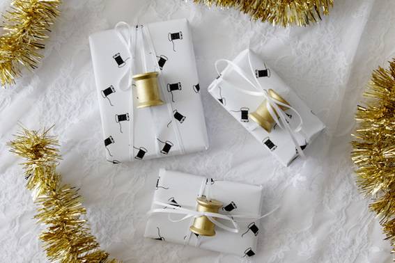 Three printable white colored gift wraps on the white cloth.