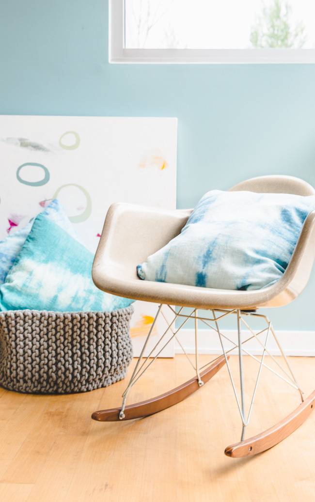 Blue color pillows in swing chair and in a knitted cloth basket.