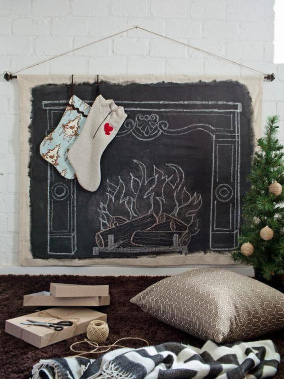 Chimney drawn on a blackboard with chalk and then hung on a wall in front of a pillow and blanket.