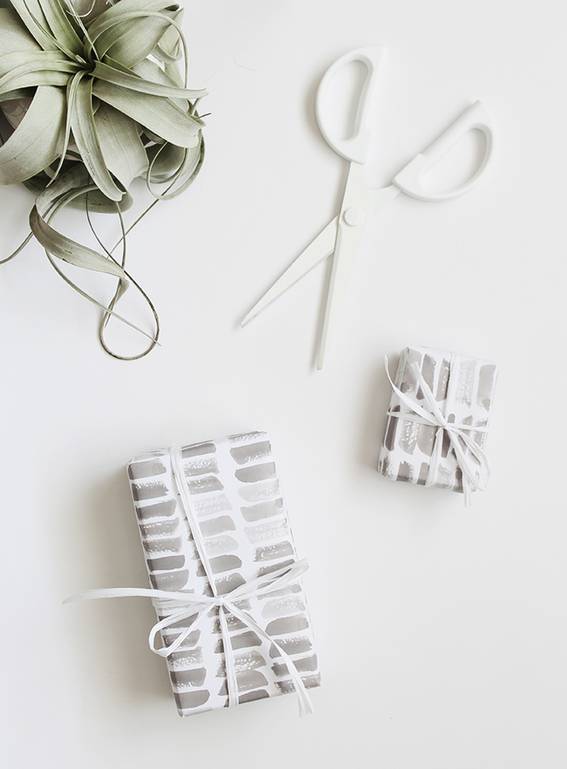 Printed gift wraps, white scissor and potted plant on the white background.