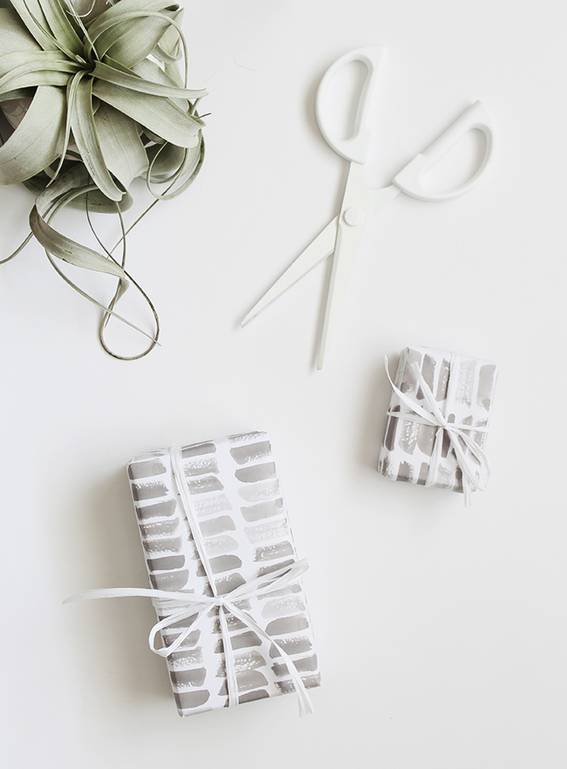 Printed gift wraps, white scissor and potted plant on the white background.