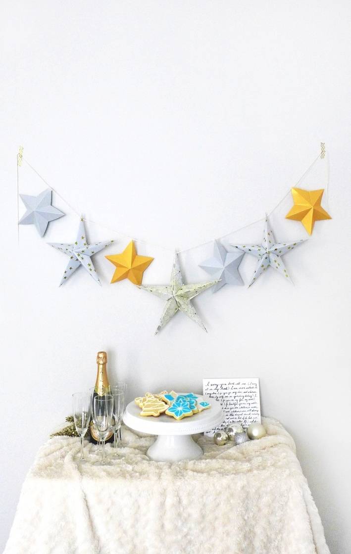Star shaped hanger is fixed on the wall and mini table along with some items are placed under the star shaped hanger.