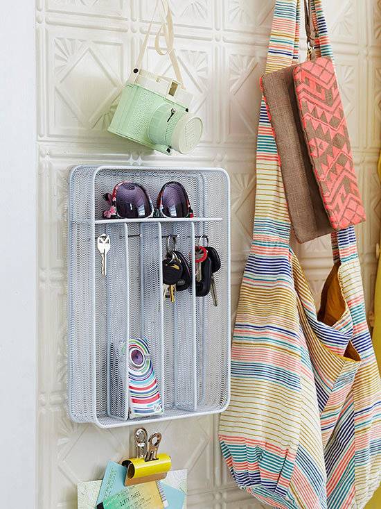 Bathroom organizer with multiple hooks and attachments for items set on a bathroom wall.