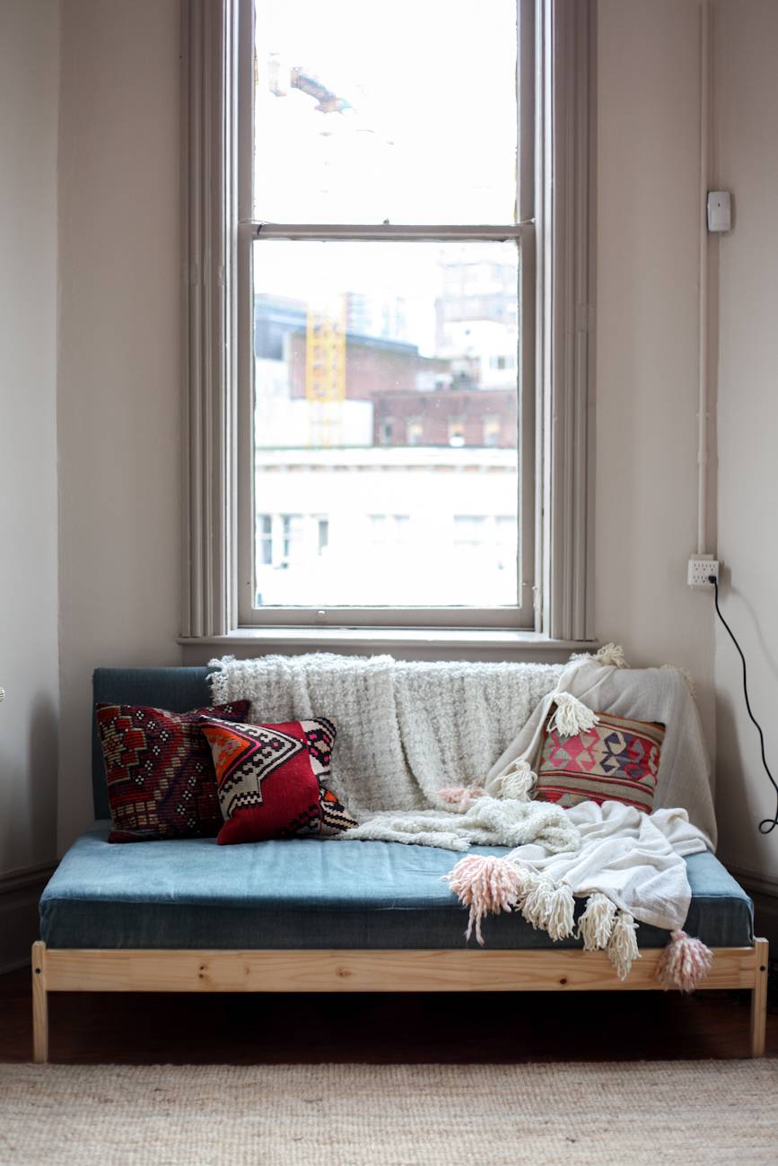 A sitting area is set up under a long and narrow window.