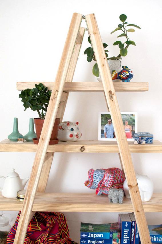 Wooden storage shelf holding potted plants and small animal figurines.