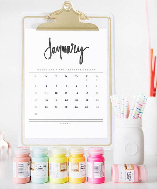 a cute white calendar with different color bottles in the bottom