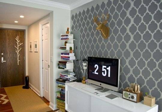 T.V. unit with gray colored wall design and books racks with lots of books in the living room.
