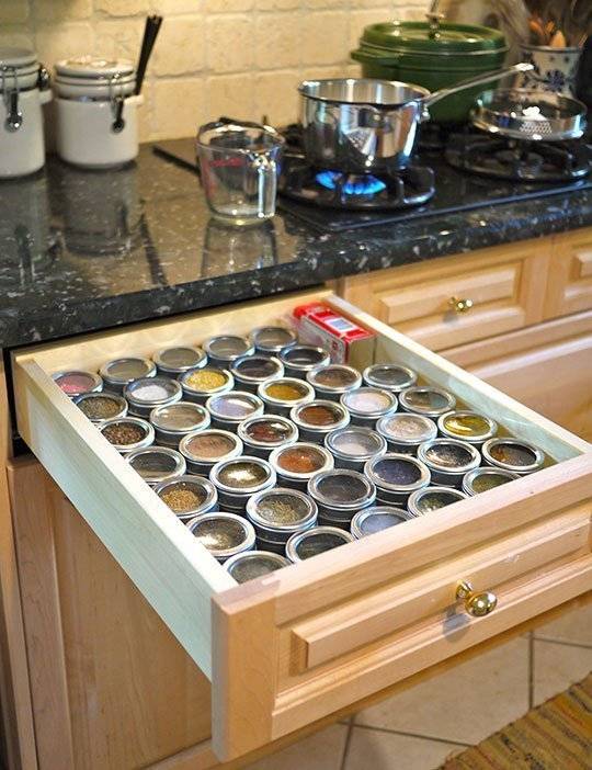 A kitchen drawer filled with small bottles of spices.