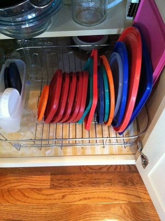 Organizing Tupperware lids in the cabinet.