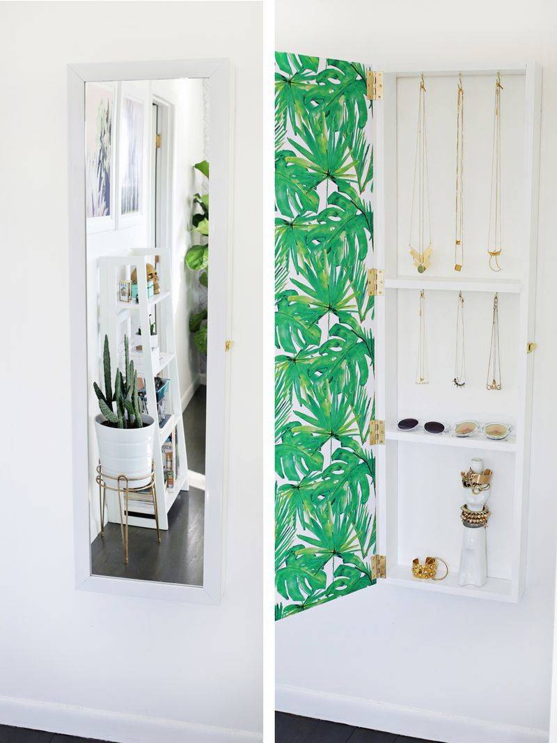 A white room has a mirror and a green part of the wall.