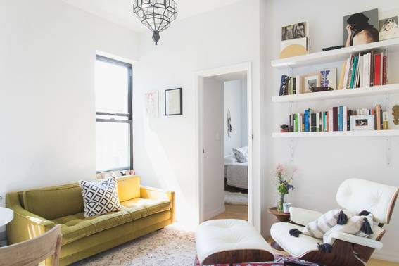 Living room with brown couch, chair, book shelf, shandler etc.