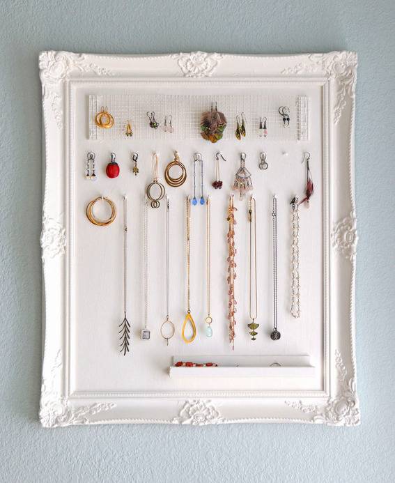 Several jewelry items hang from a white plaque.