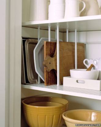 Kitchen cabinets with slots for plates and others for bowls of different sizes built into the side of wall.