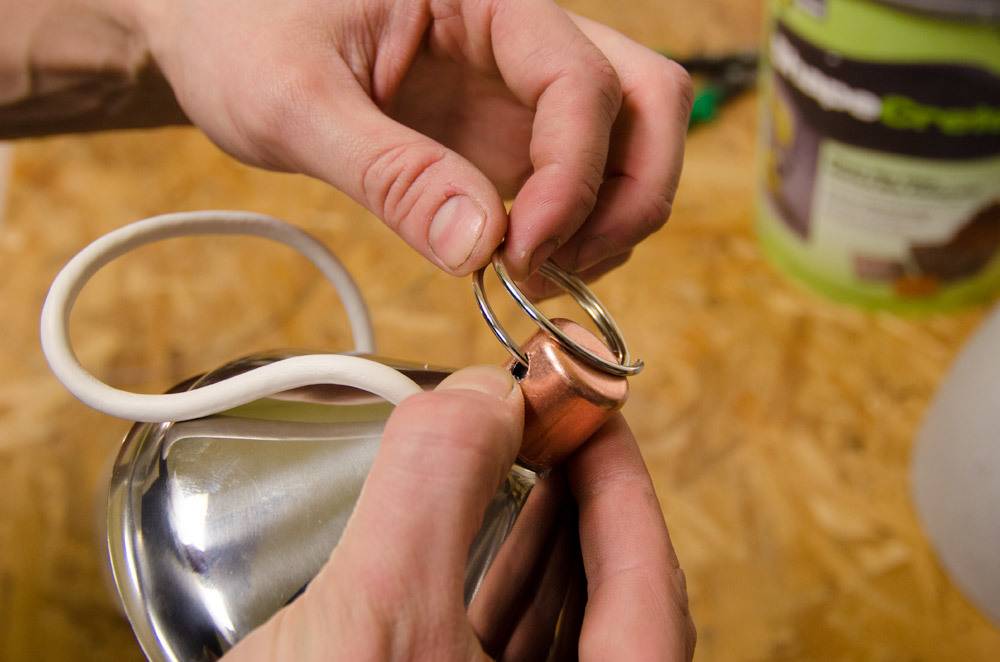 A person assembling a ring on a silver object.