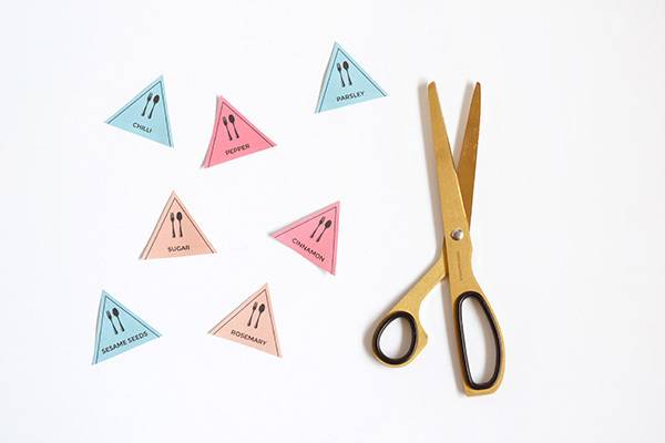 Scissors sit next to several triangular pieces of paper.