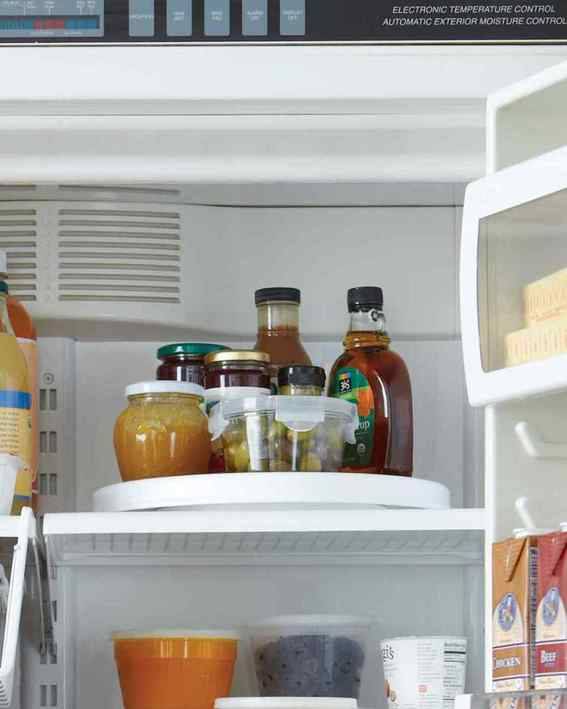 Drinks and bottles fill the top shelf of a refridgerator.