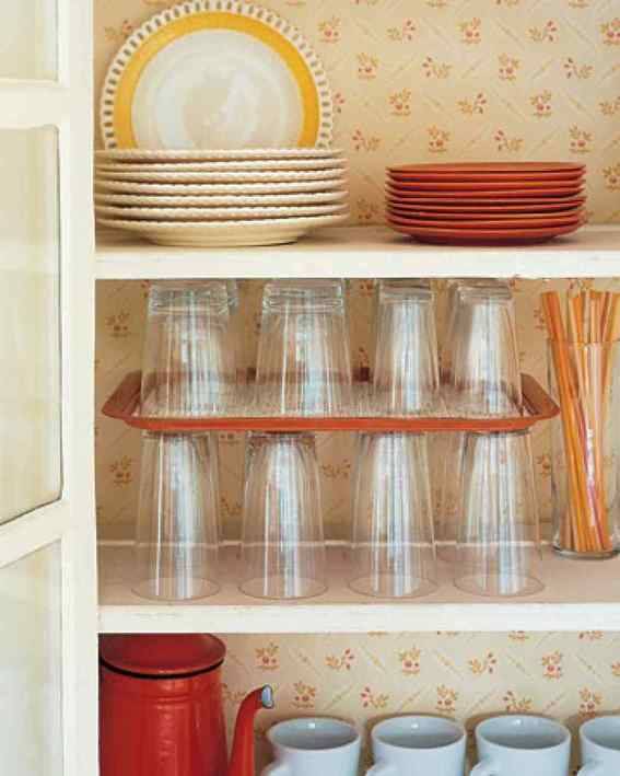 Plates, glasses, straws, kettle and cups in a kitchen rack.