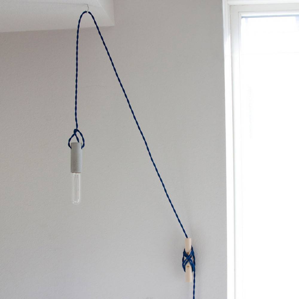 Something is hanging from a string attached to a wall.