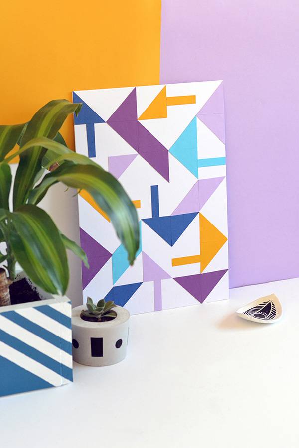 A colorful print with arrows is displayed near a plant.