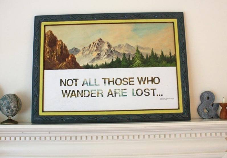 Painting lying on top of wall rack having an image and a message written on it.