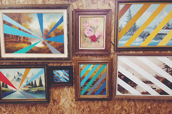 A collection of seven framed pictures, four with diagonal colored lines across the front and two with colored converging lines.